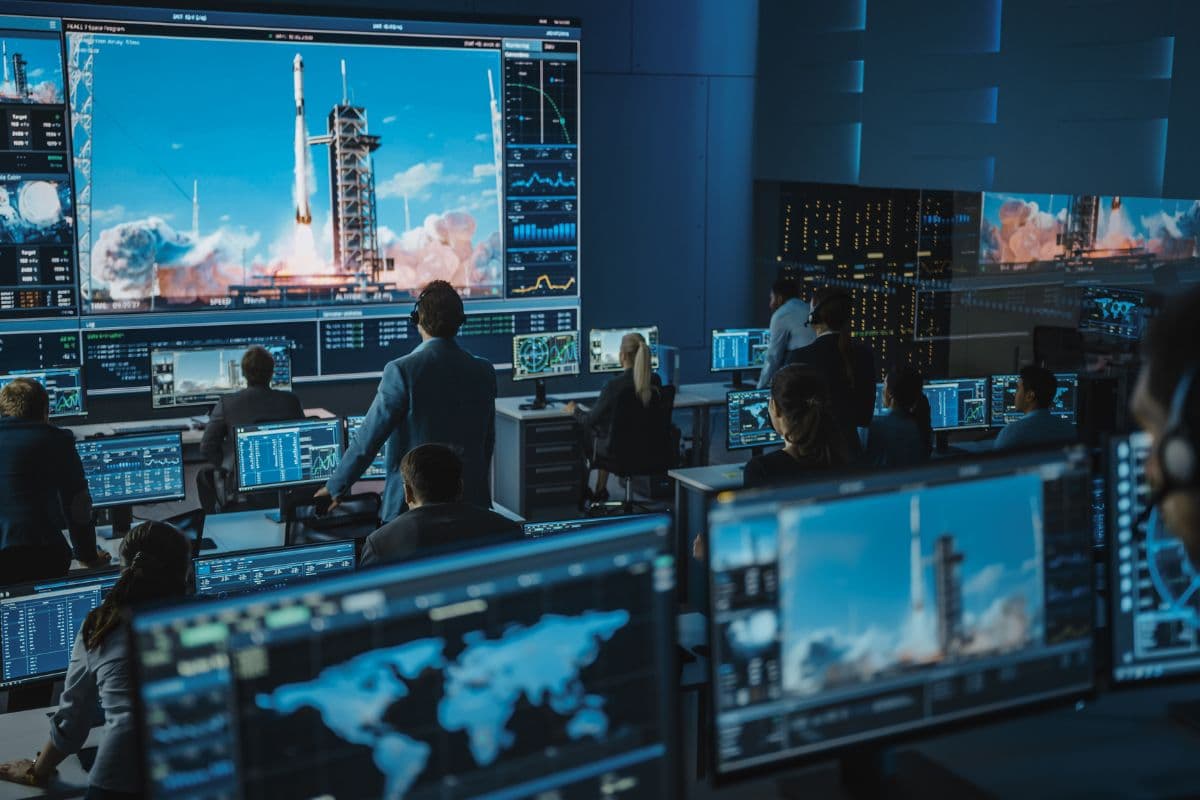 Des pilotes contrôlent des indicateurs comme des KPI Google Ads dans un centre spatial